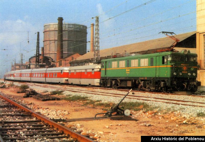 08408 Estació del Poblenou 1981 Talgo III arrossegat per una locomotora elèctrica 269-098-0. Al fons el gasòmetre i MACOSA.